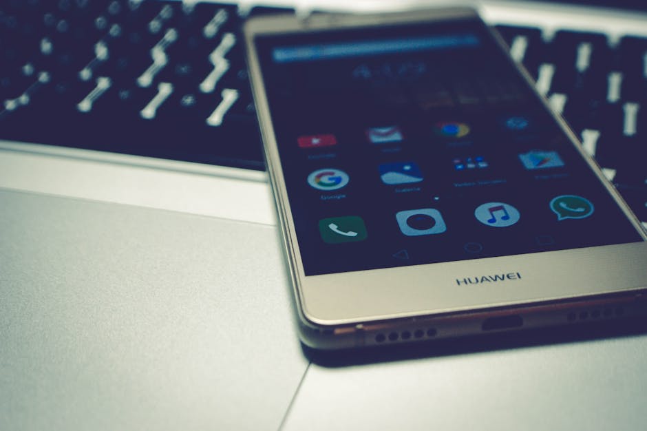 Close-up of a smartphone placed on a laptop keyboard, highlighting digital interaction.